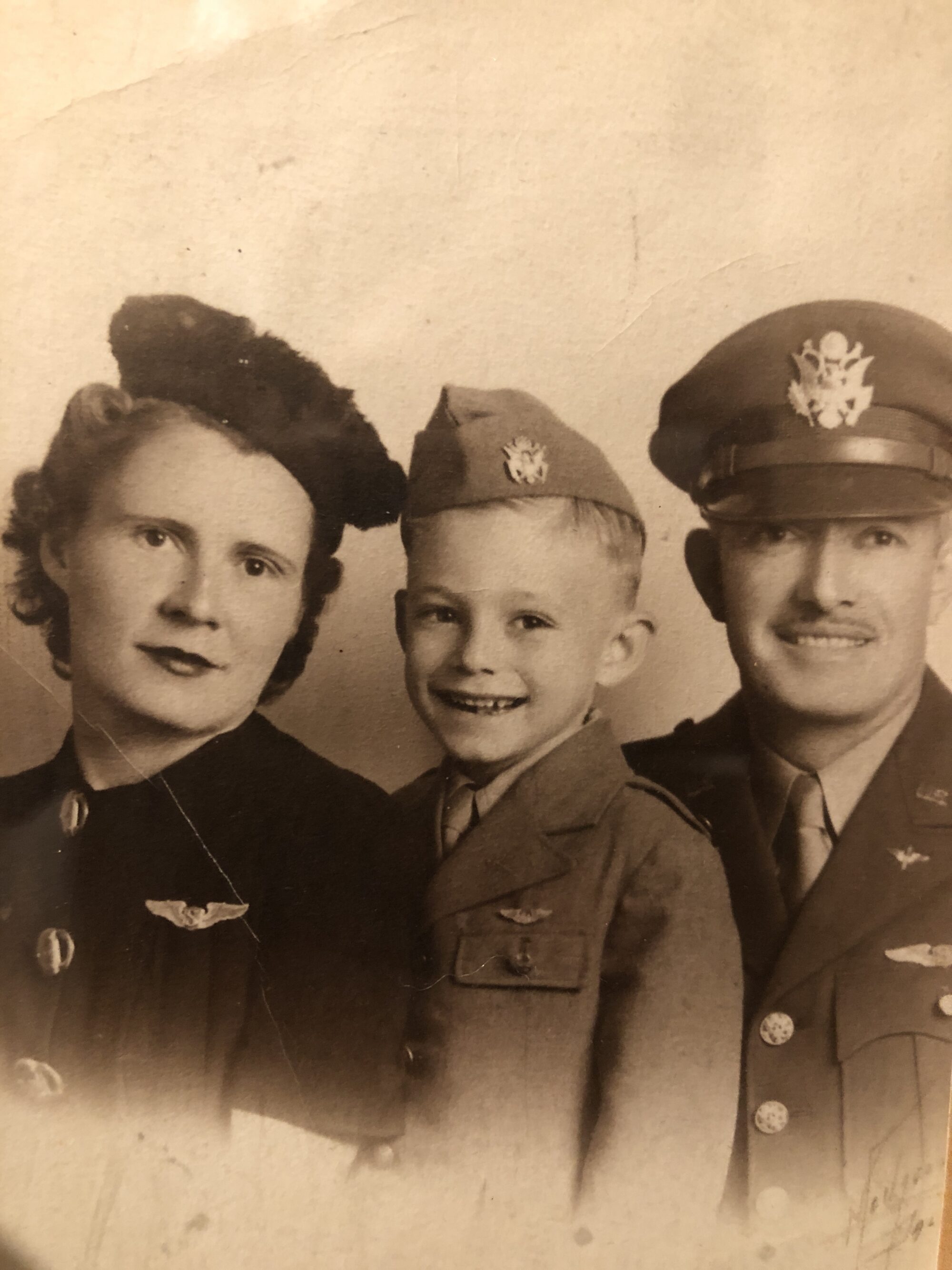 Black and white photo of a woman, man, and young boy all wearing military uniforms.