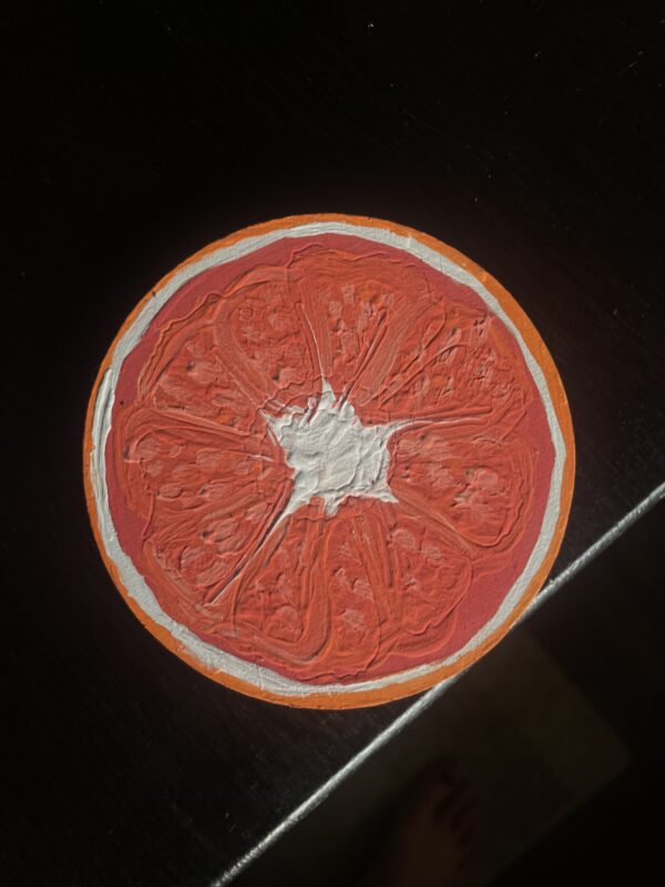 Photo of a round coaster painted like a grapefruit slice.
