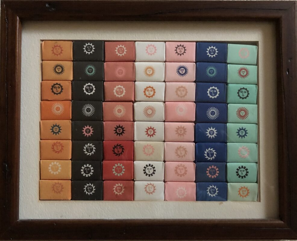 Photo of a framed set of wrapped rectangular sugar cubes with designs in various colors.