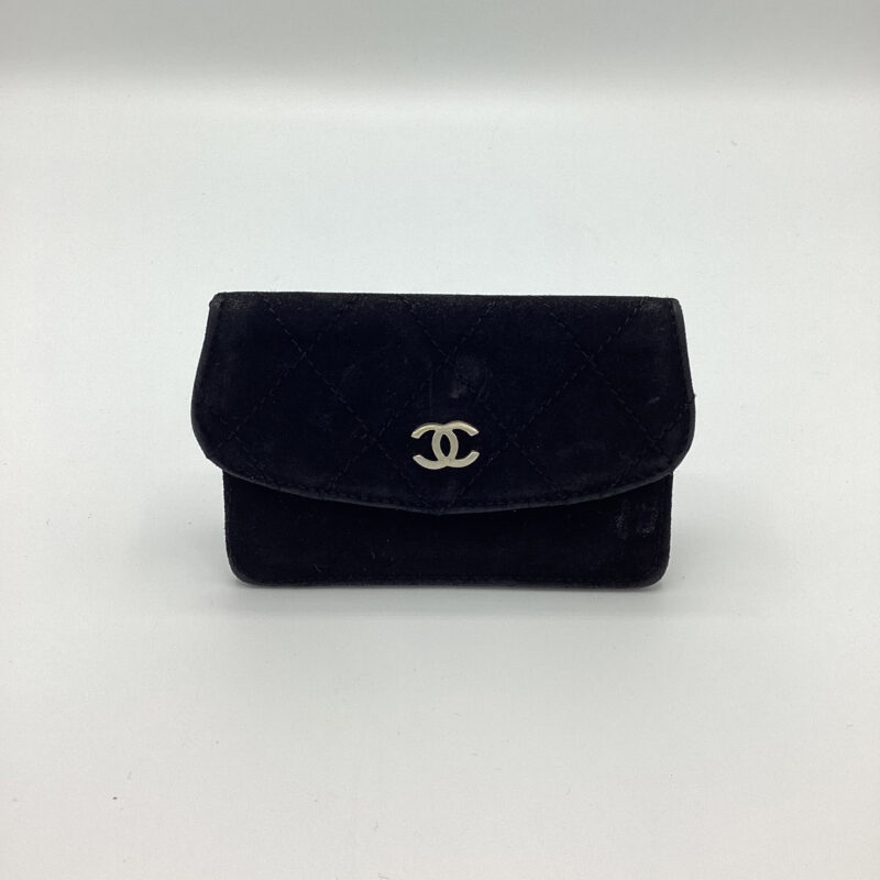 Photo of a small black wallet with a silver Chanel emblem.