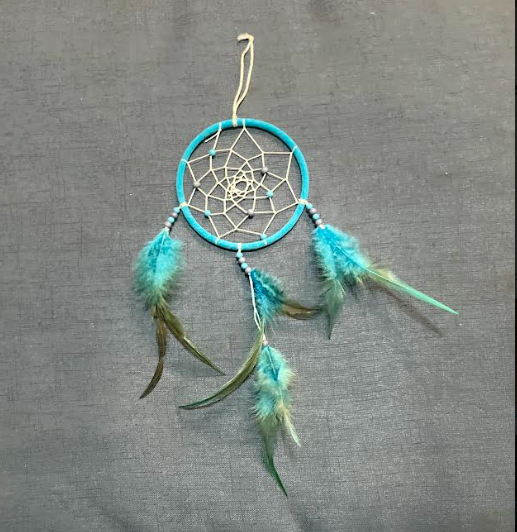 Photo of a small blue dreamcatcher with blue feathers.