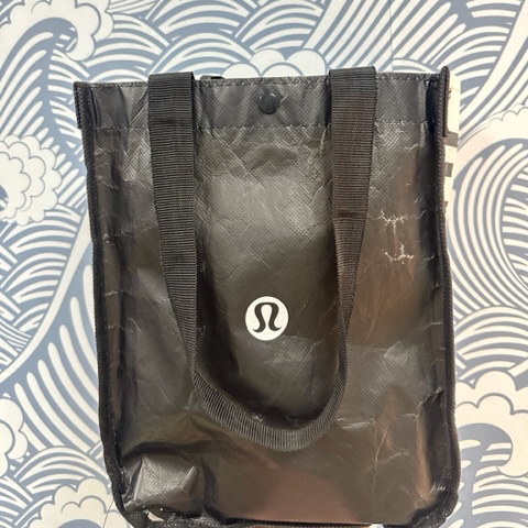 Photo of a black tote bag with a small white Lululemon logo.