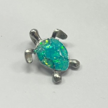 Photo of a small metal turtle with a blue-green gemstone shell.